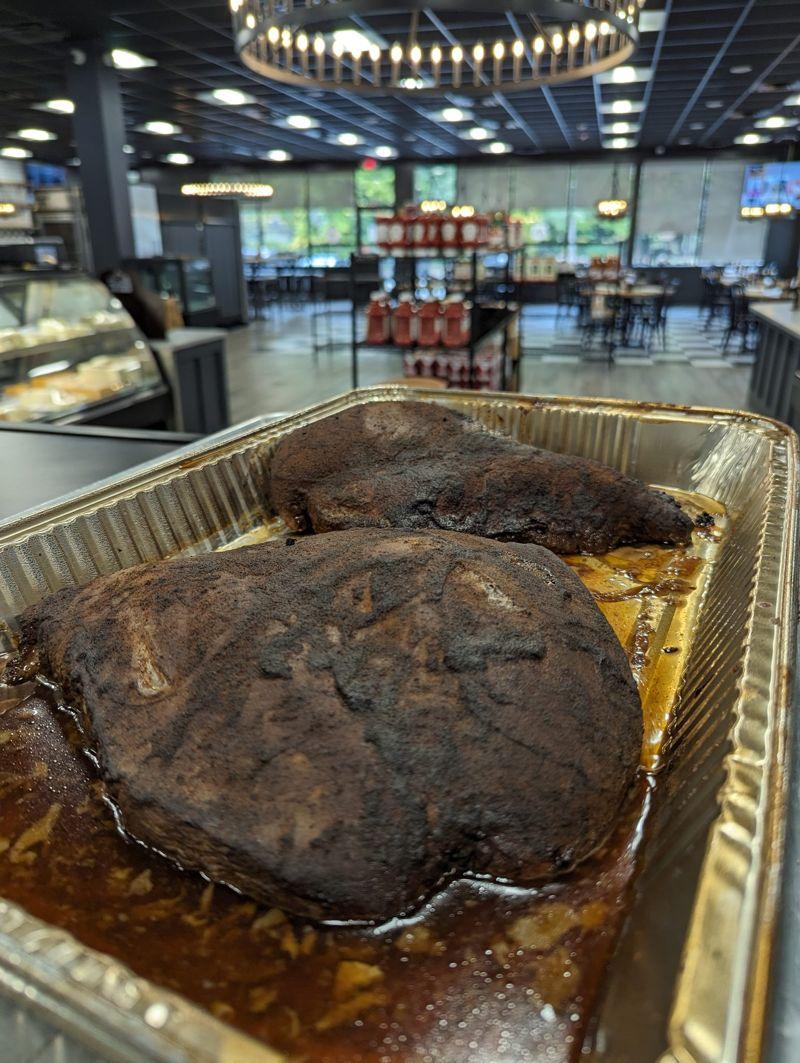 Two whole smoked pork butts in a foil pan